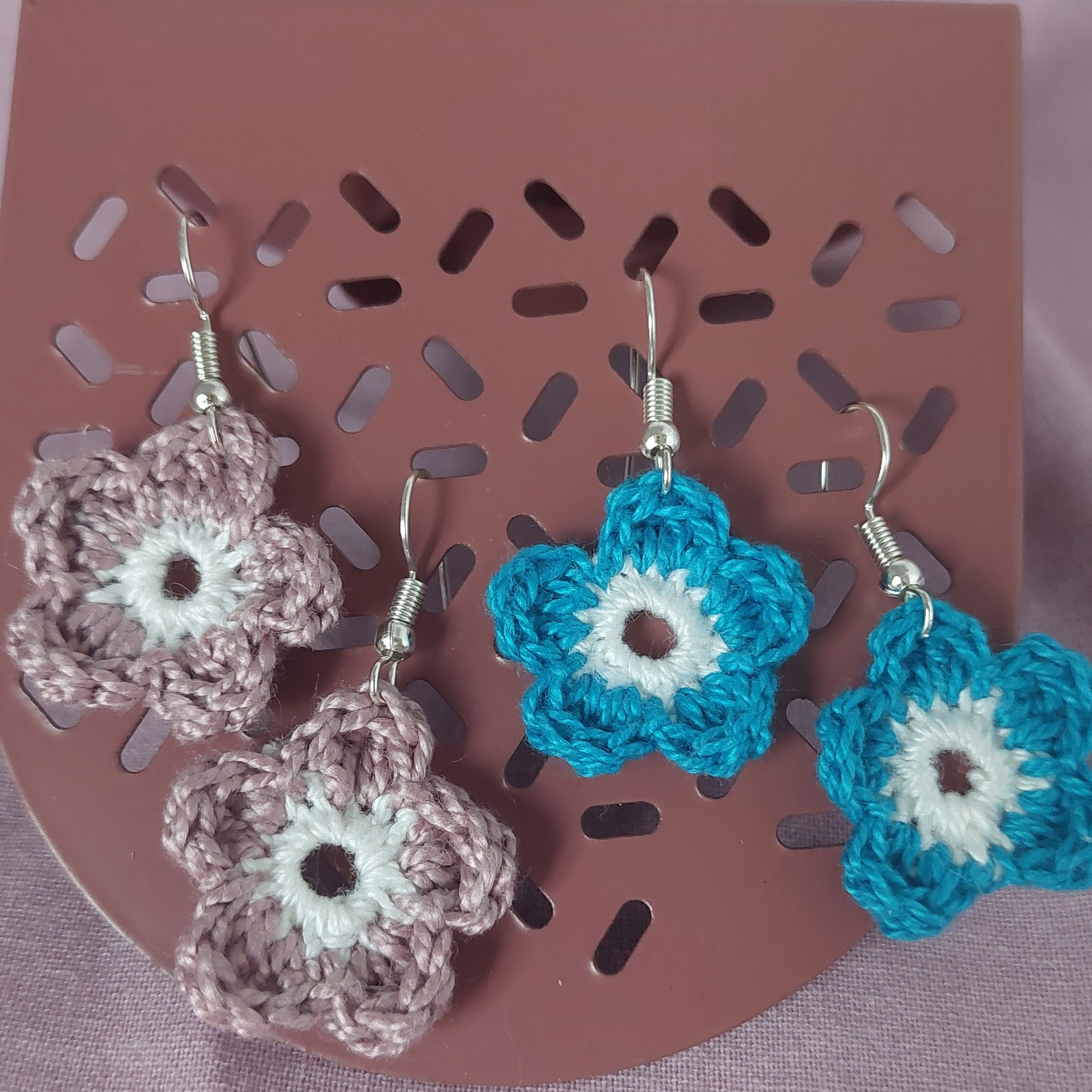 Boucles d'oreilles en forme de fleurs réalisées au crochet.
